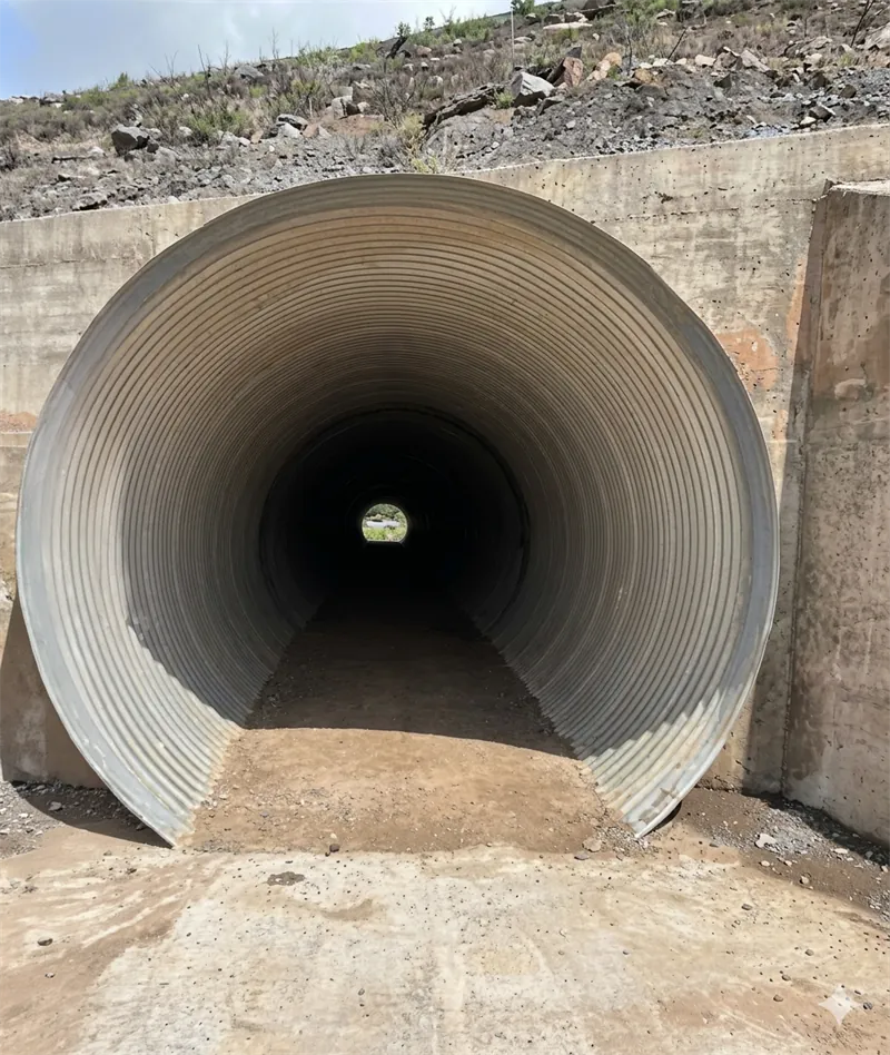 Paso de tubería HULKO de acero galvanizado corrugado bajo un terraplén