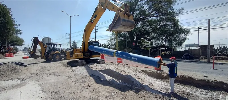 Maniobra de tubería con excavadora sobre la vialidad