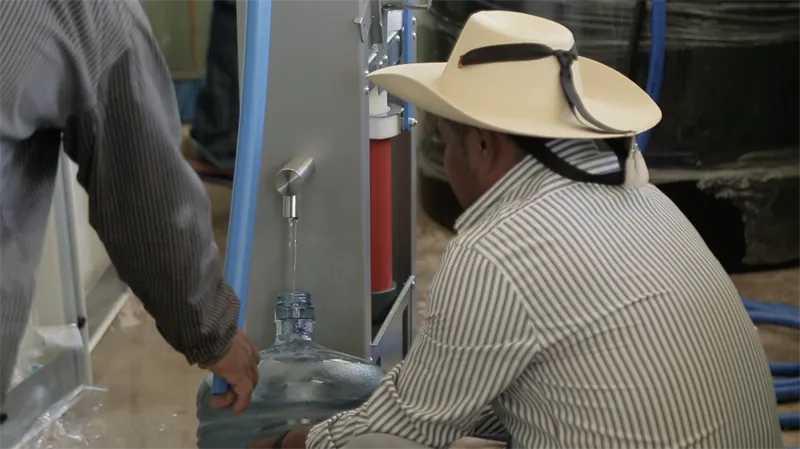 Usuario llenando un garrafón en una planta Villagepump