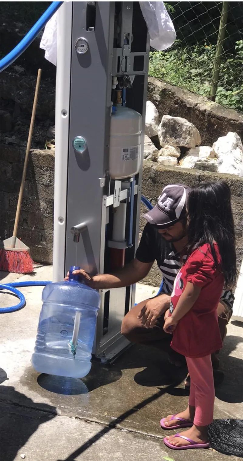 Niña llenando un garrafón en la planta Villagepump