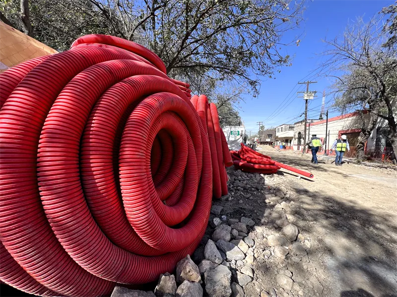 Rollos de tubería Conduit roja en obra urbana